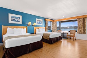 A hotel room with two beds, a dining table, and a view of the sea. - Skylark Shores Resort (Lakeport)