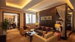 A hotel room with a seating area, a bed, and a large window. - Xianheng Hotel (Shaoxing)