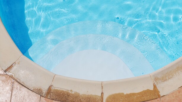 Ein Schwimmbecken mit klarem, blauem Wasser und einer gefliesten Kante.