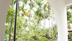 An indoor garden with potted plants and a brick wall. - Yen Villa Hoi An (Da Nang)