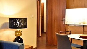 A modern kitchen with wooden cabinets, a dining table, and chairs. - Ribeira Oporto Apartment (New) (Porto)