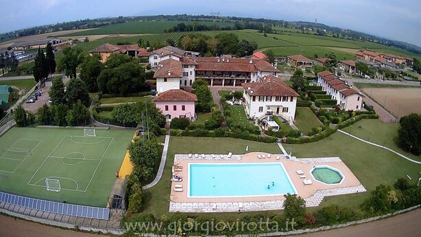 An aerial view of a residential area with houses, a tennis court, and a swimming pool. - "DESIGNcontrodesign  (desenzano)