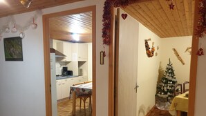 Una cocina con armarios blancos, una mesa de comedor y un árbol de Navidad.