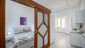 Une chambre à coucher avec un lit, une table de chevet, une lampe et un tableau au mur.