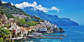 A coastal town with buildings on a hillside, a marina with boats, and a clear blue sea. - Vomero, close to Metro 1, bars restaurants and shopping ☀️JOLI MIRANDA Apartment (NAPOLI)