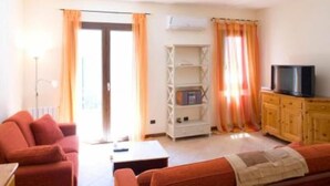 A living room with a sofa, a television, and a cabinet. - MAGNIFICENT, WARM APARTMENT IN THE HEART OF A TYPICAL SICILIAN VILLAGE! (Torretta)