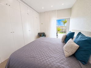 A bedroom with a bed, pillows, a chair, and a view of the outdoors. - Spacious 5BR Villa in Costa Adeje with Private Pool (Costa Adeje)