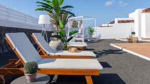 A rooftop lounge area with sun loungers, a small table with a potted plant, and a white gazebo. - Villa Guájara  (Playa Blanca)
