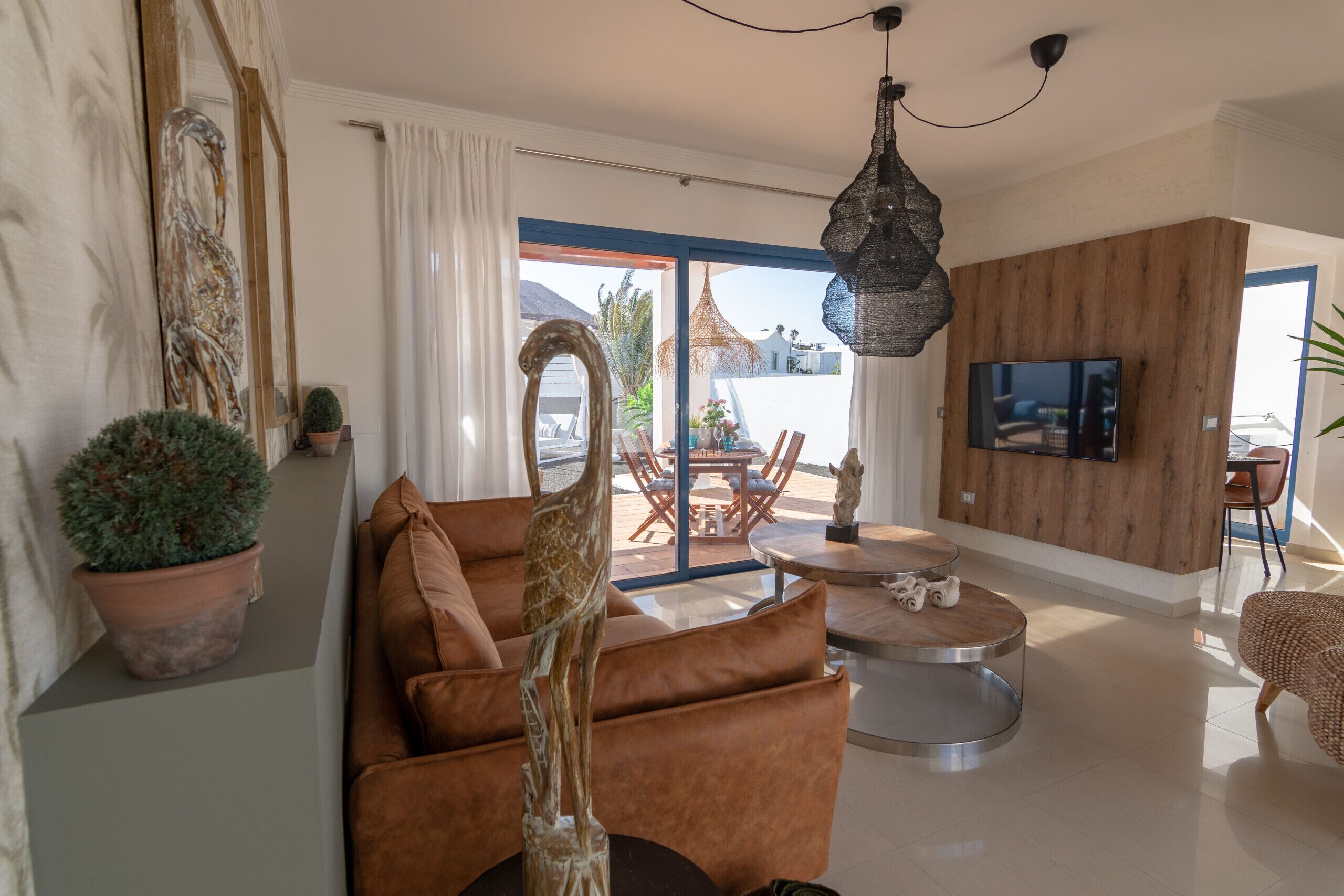 Ein modernes Wohnzimmer mit einer Couch, einem runden Couchtisch und einem an einer Holzwand montierten Fernseher.