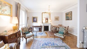 A traditional room with a fireplace, wooden furniture, and patterned rugs. - Saint-Germain des Prés Allure, by Veeve (Paris)