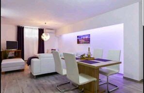 Departamento Deluxe, 1 habitación | Área de sala de estar | Televisión de pantalla plana