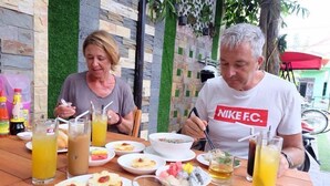 Two people dining at an outdoor table with various dishes and drinks. - Bean Grass Homestay (Da Nang)