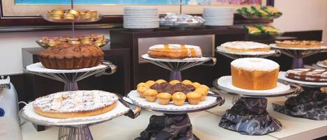 Uma mesa de buffet com diversos doces e pâtisseries.