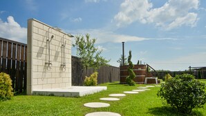 A backyard with a brick wall, a wooden fence, and a garden with stepping stones.