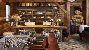 Un interior rústico con paredes de madera, un escritorio de madera y una colección de libros y objetos decorativos.