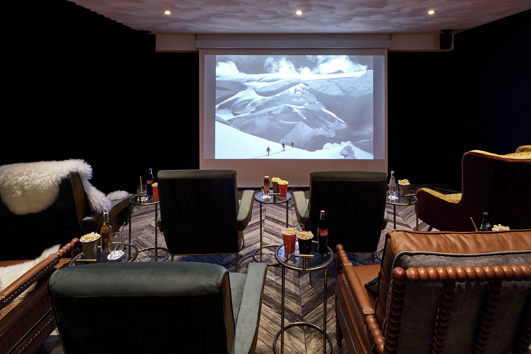 A movie theater with plush seating, a large screen, and a cozy ambiance.