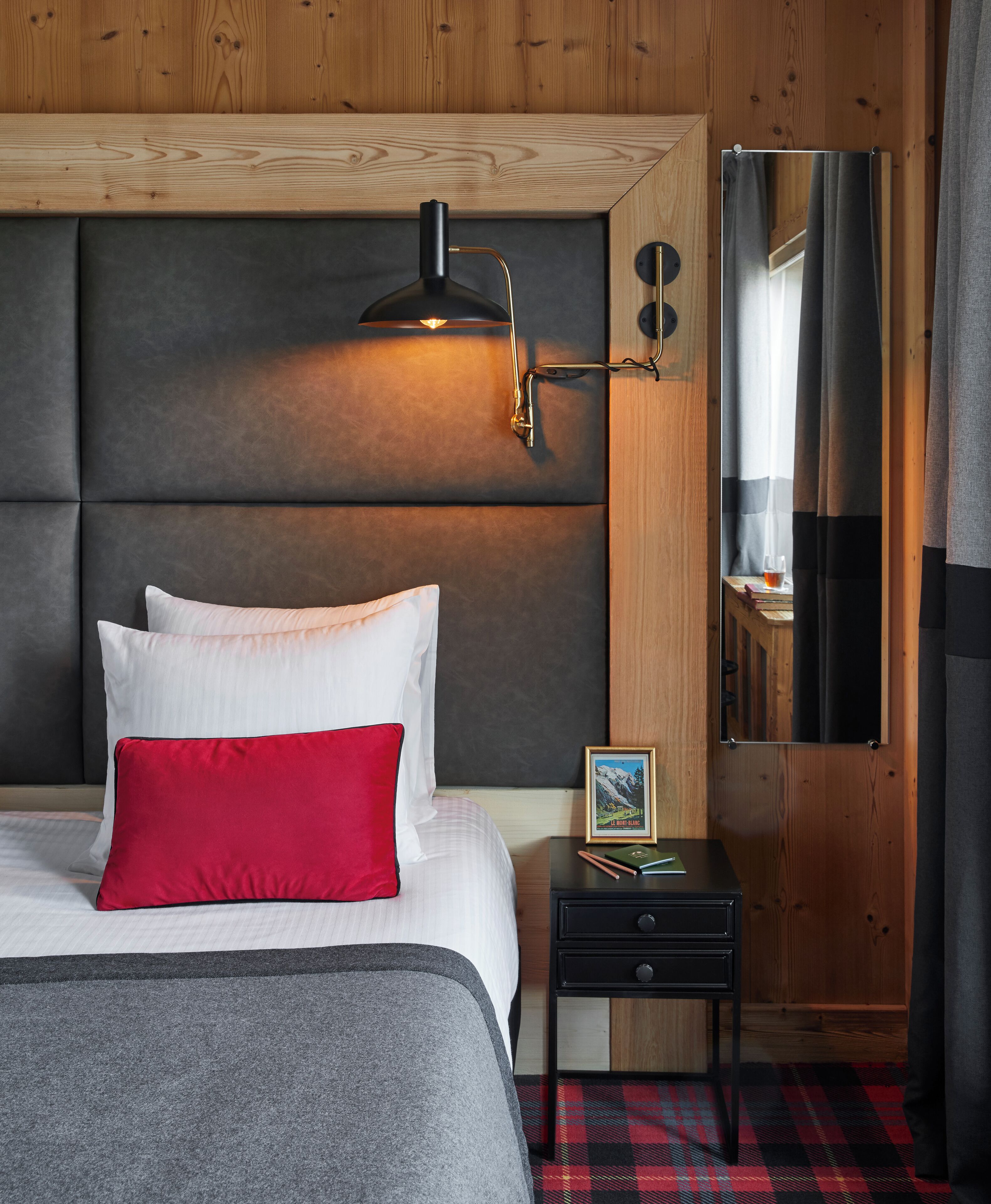 Una camera da letto con un letto grande, un comodino con una cornice e uno specchio a parete.