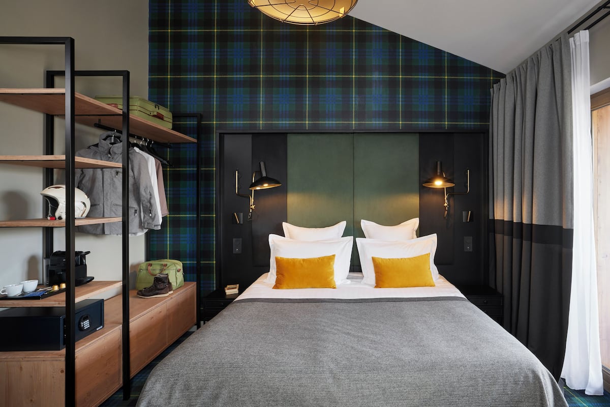 A modern bedroom with a bed, wardrobe, and a view of the outdoors.