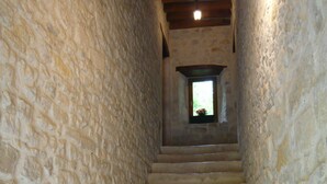 A stone staircase leading to a window with a view of greenery. - La Ferme Manoir Saint Barthélemy (Juaye-Mondaye)