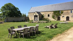 A stone building with a large lawn, outdoor seating, and a dirt path. - La Ferme Manoir Saint Barthélemy (Juaye-Mondaye)