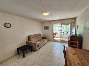 A living room with a sofa, a small table, a wooden dining table, and a clock on the wall. - at five minute at walk of the beach, at calm (ST MANDRIER SUR MER)