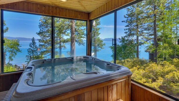 A hot tub in a wooden cabin with large windows overlooking a lake and trees. - Anchors Aweigh - Lakefront - TLUXP (Tahoe City)