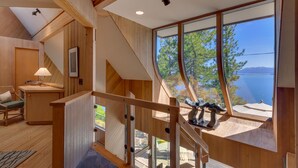 A wooden interior with a staircase leading to a balcony overlooking a lake. - Anchors Aweigh - Lakefront - TLUXP (Tahoe City)