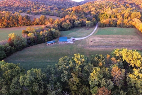 Drone over river looking back at the farm.