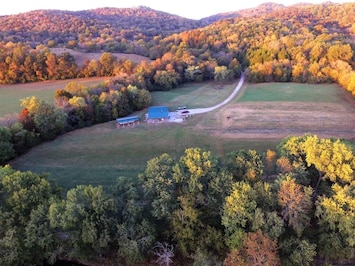 Drone over river looking back at the farm.