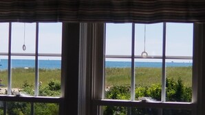 Une vue à travers une fenêtre donnant sur la plage et la mer.