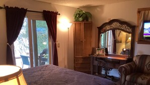 Ein Schlafzimmer mit Bett, Schreibtisch, Stuhl, Kleiderschrank und Spiegel.