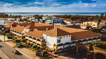 A hotel with a sign, multiple buildings, and a road.