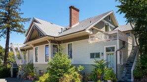 A two-story house with a front porch, a staircase, and a brick chimney.