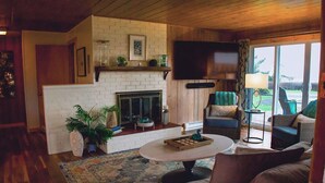 A cozy living room with a fireplace, comfortable seating, and a television.