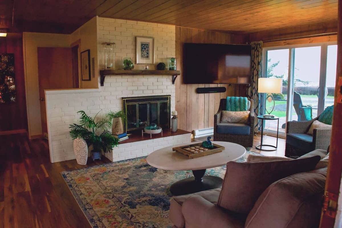 A cozy living room with a fireplace, comfortable seating, and a television.