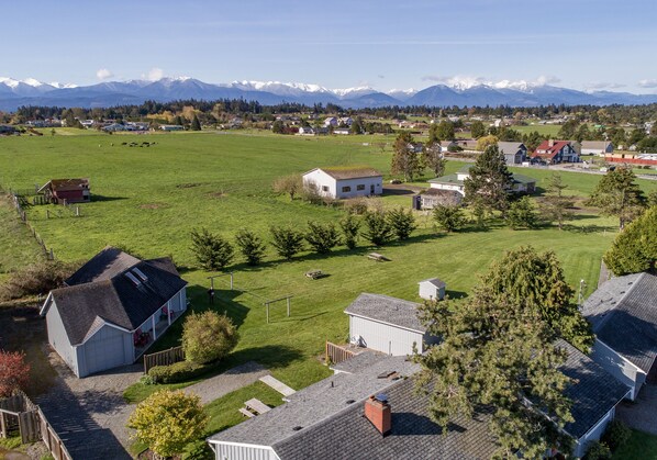 A rural landscape with houses, a barn, and a field. - Dungeness Bay Cottages (Sequim)
