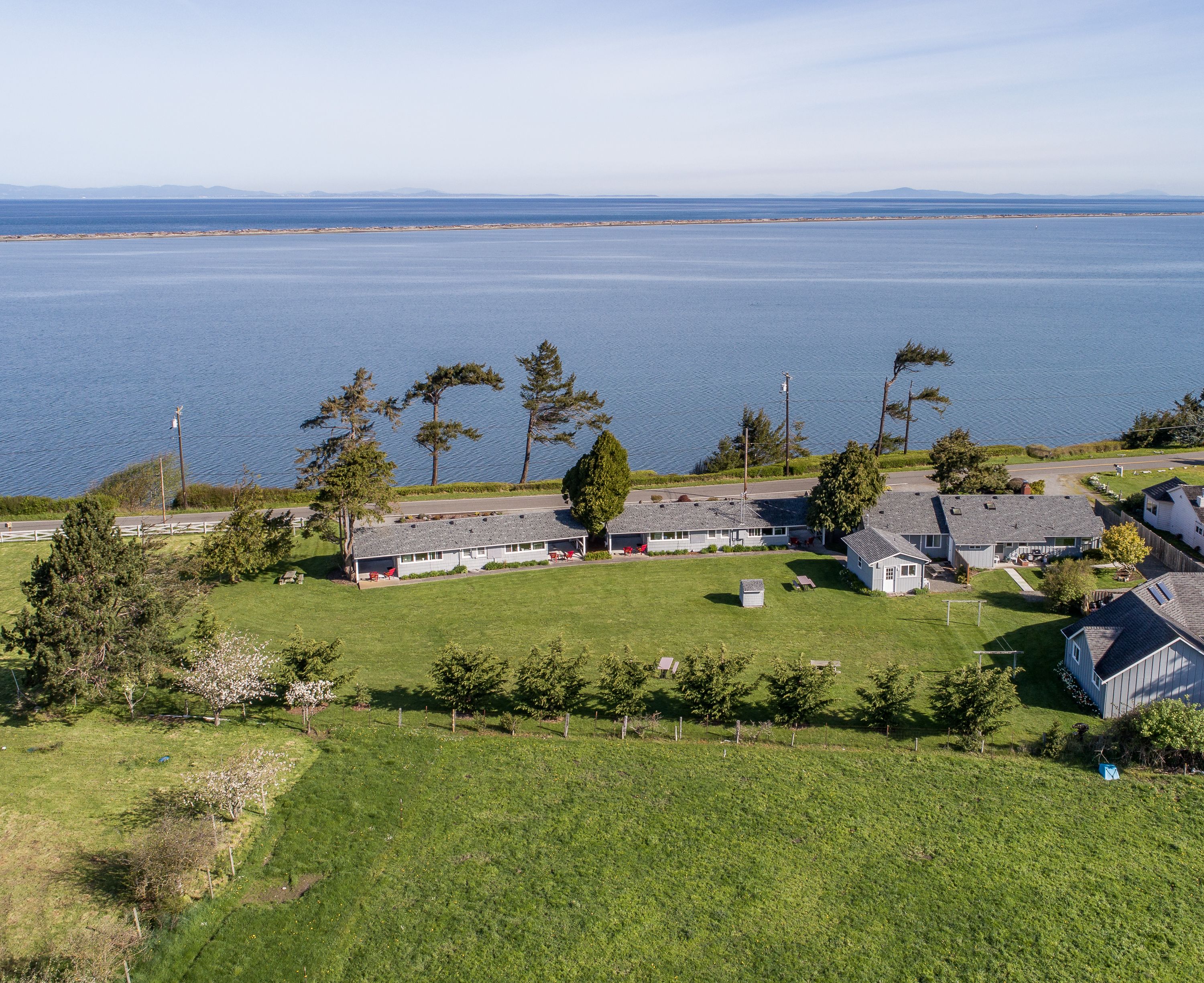 Una proprietà costiera con diversi edifici, un'area verde e vista sul mare.