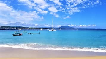 Una playa cerca, sillas reclinables de playa, toallas de playa