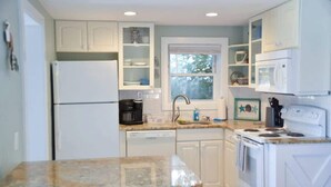A kitchen with white cabinets, a dishwasher, a stove, and a window. - Steps to Beach 2BR 2BA duplex (Atlantic Beach)