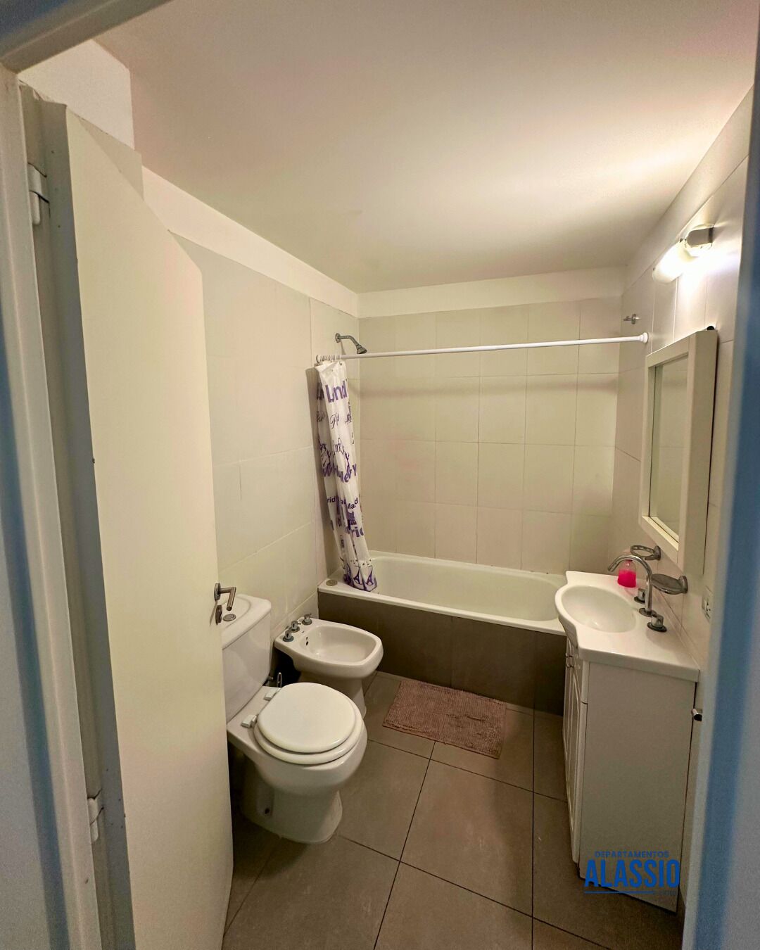 A compact bathroom with a toilet, bidet, bathtub, and sink.