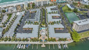 An aerial view of a coastal hotel area with multiple buildings, a marina, and a beach.