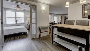 A modern bedroom with a bed, a desk, and a dining area.