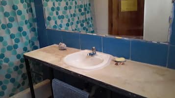Baño con lavamanos, espejo y azulejos azules de patrón hexagonal.