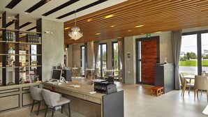 A modern hotel lobby with a reception desk, bar area, and seating. - LaFika (Dongshan)