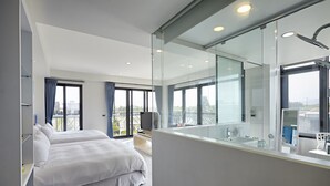 A modern hotel room with a large bed, a TV, a bathroom with a large mirror, and a balcony with a view. - LaFika (Dongshan)