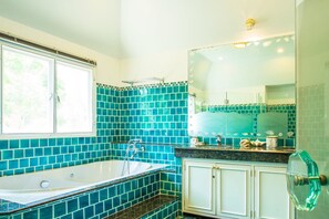 A bathroom with a bathtub, a window, and a mirror. - Prompimarn Villa (Pranburi)