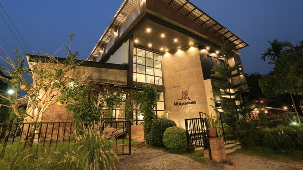 Un edificio moderno con una entrada amplia, un logotipo visible y una fachada bien iluminada.