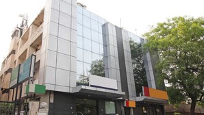 A modern building with a reflective glass facade, a flat roof, and a mix of commercial and residential spaces. - Southview Apartment (New Delhi)