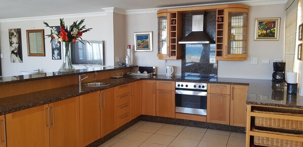 A modern kitchen with wooden cabinets, a stainless steel oven, and granite countertops.
