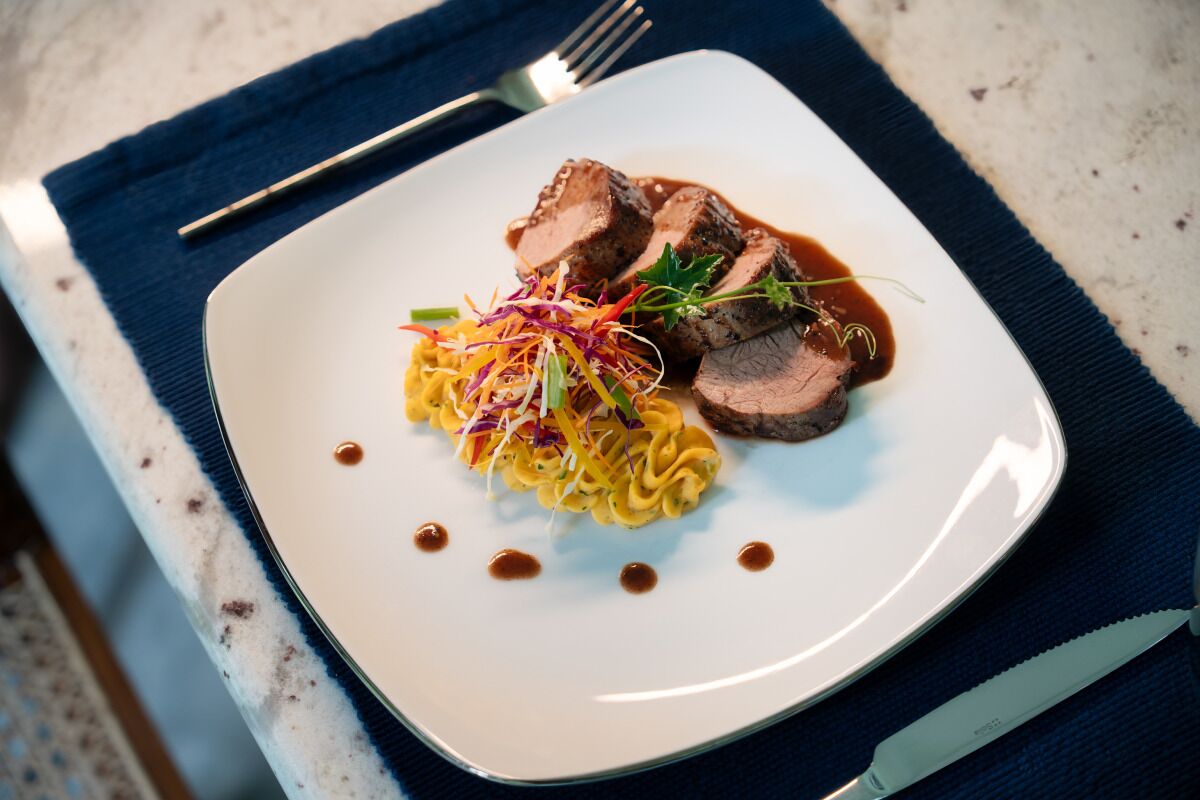 A plate with food, a fork, and a knife on a table.